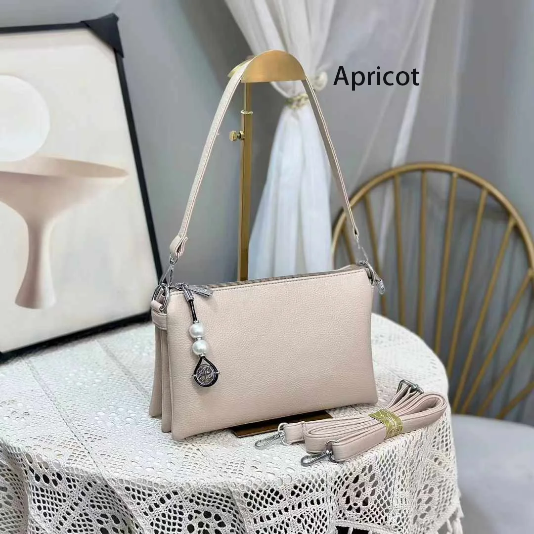 Faux leather crossbody bag with a pearl pendant and chain shoulder strap. 