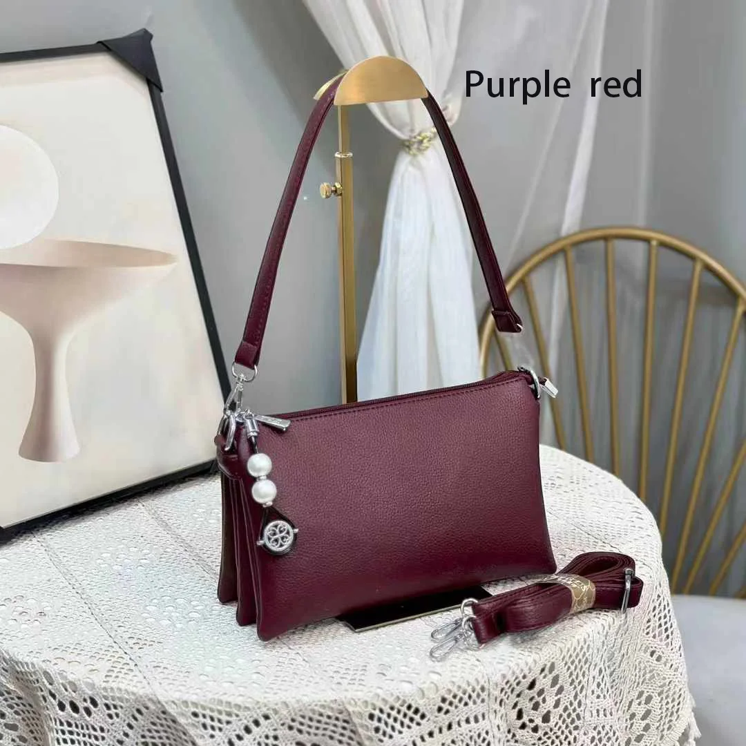 Faux leather crossbody bag with a pearl pendant and chain shoulder strap. 