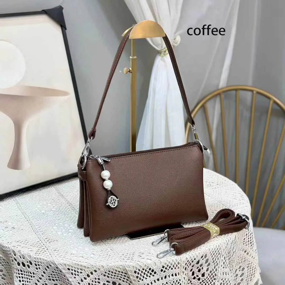 Faux leather crossbody bag with a pearl pendant and chain shoulder strap. 