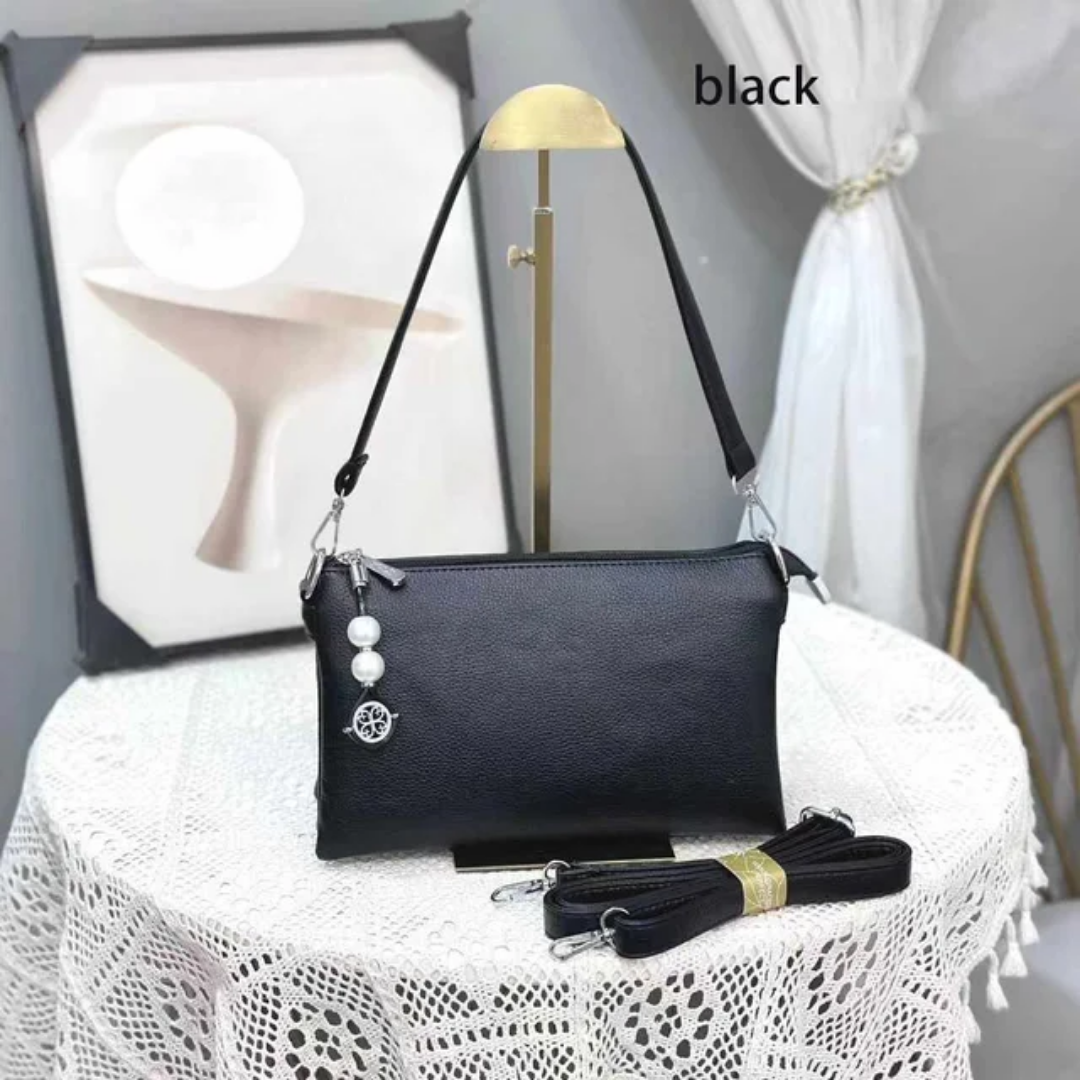 Faux leather crossbody bag with a pearl pendant and chain shoulder strap. 