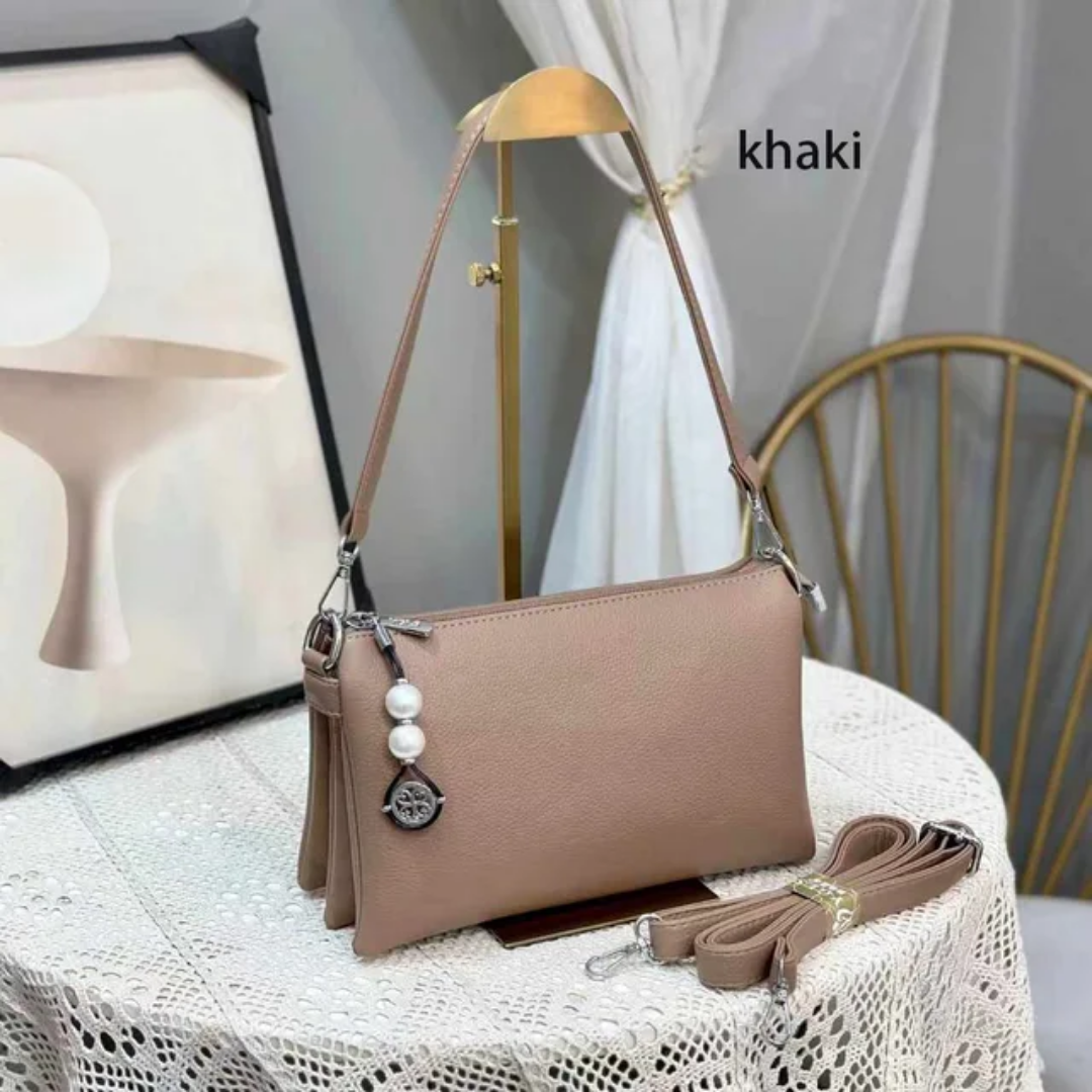 Faux leather crossbody bag with a pearl pendant and chain shoulder strap. 