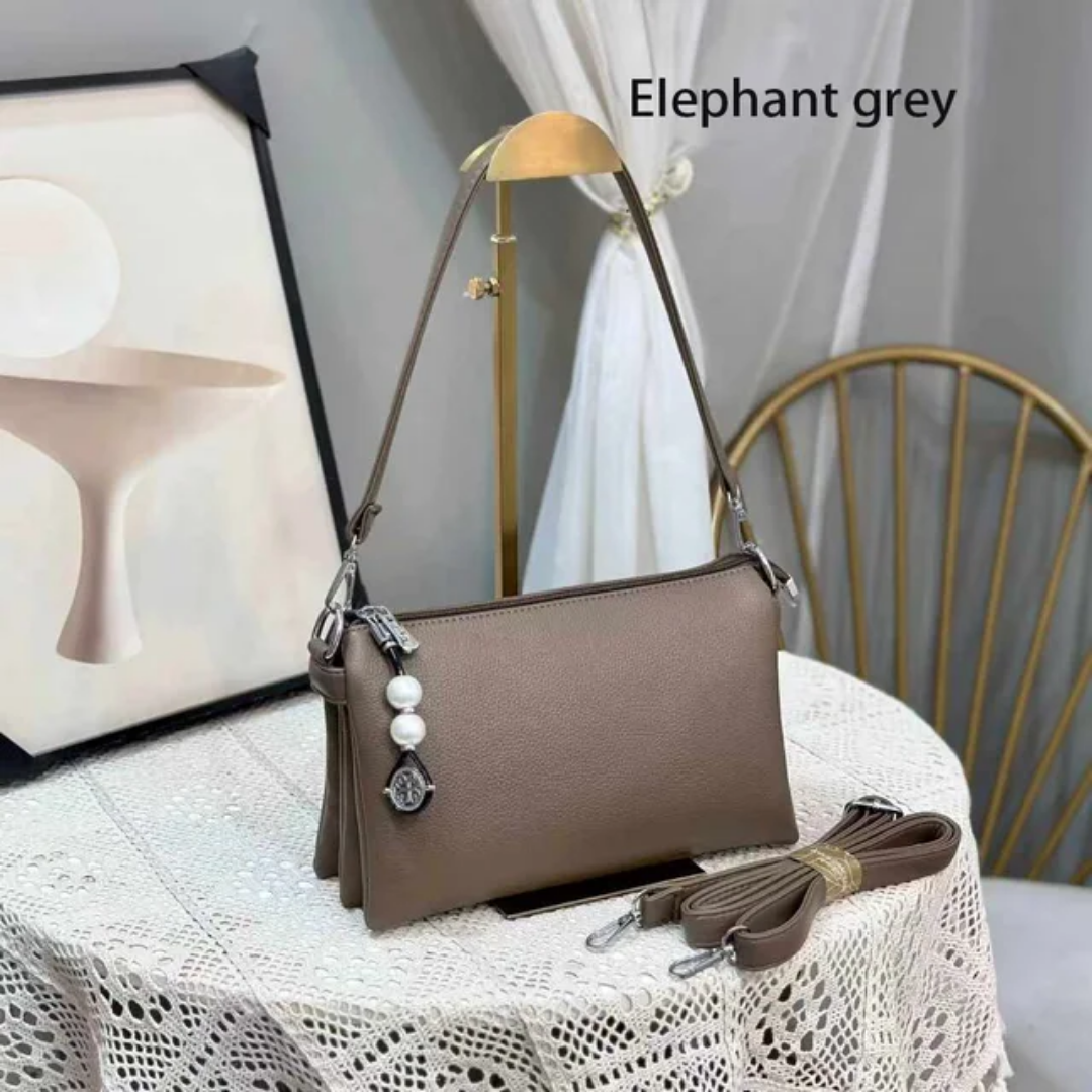 Faux leather crossbody bag with a pearl pendant and chain shoulder strap. 