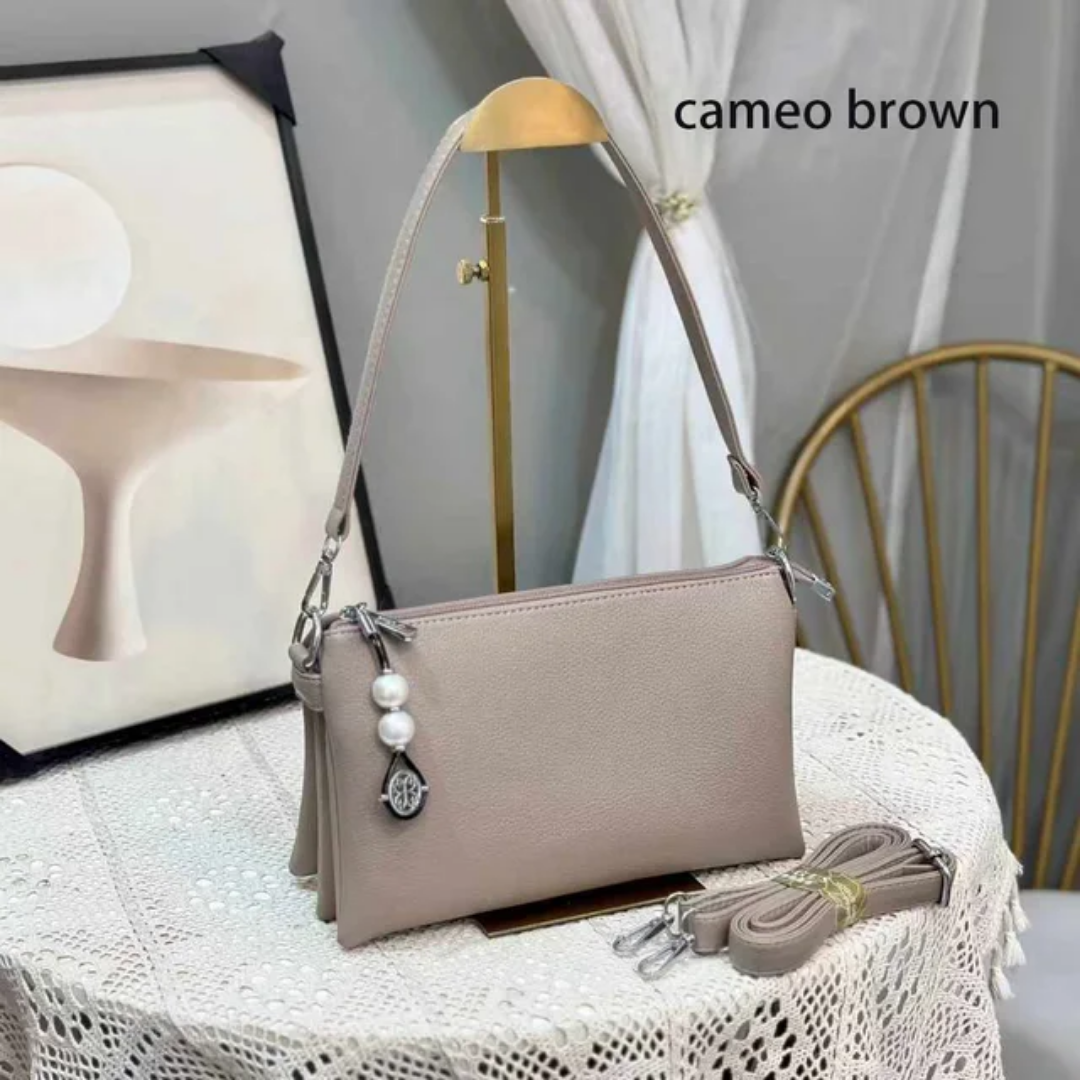 Faux leather crossbody bag with a pearl pendant and chain shoulder strap. 